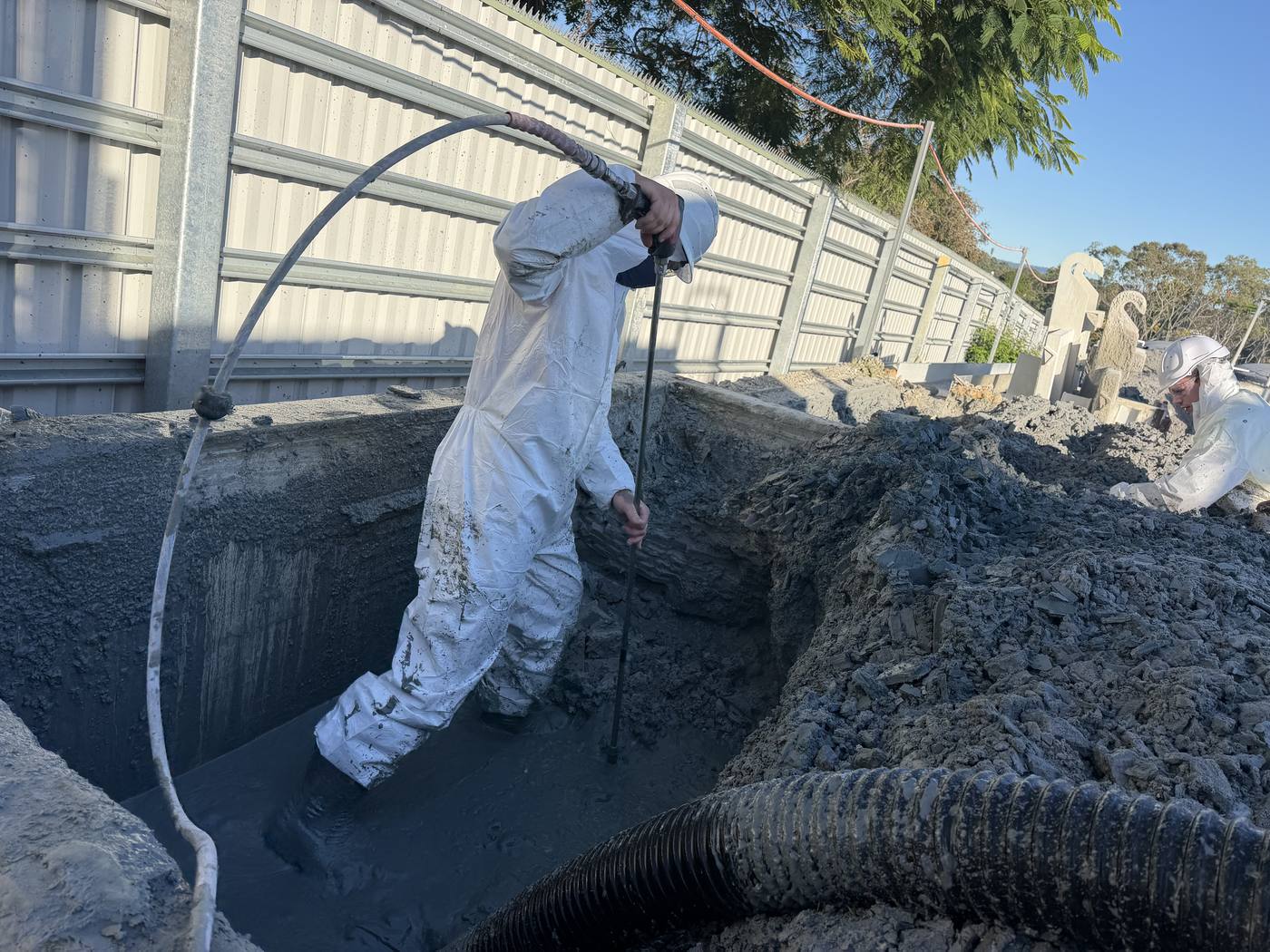 KVAC operators in full PPE cleaning out a large sludge tank